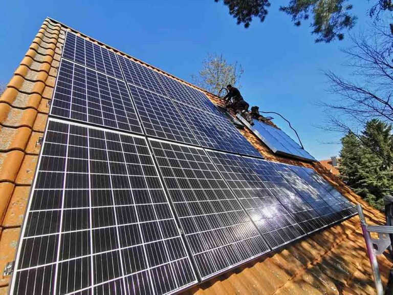 ein Monteur installiert eine Solaranlage auf einem Dach